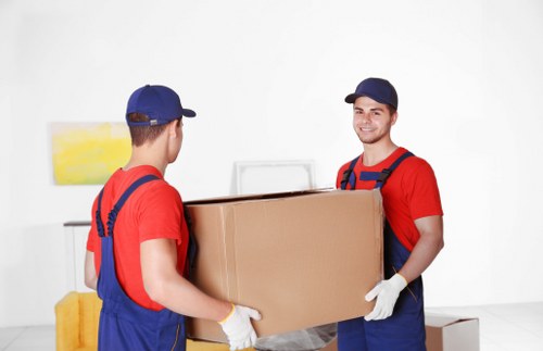 Local movers handling furniture through a narrow staircase in Islington
