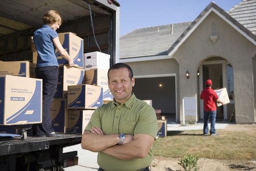 House movers handling furniture and loading outside an Islington home