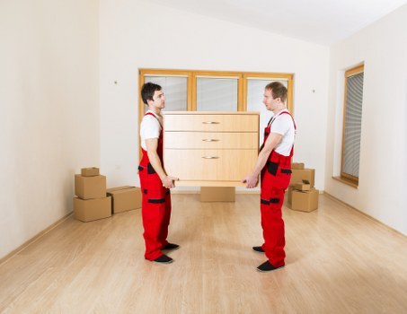 Removal workers handling household items in an Islington flat move